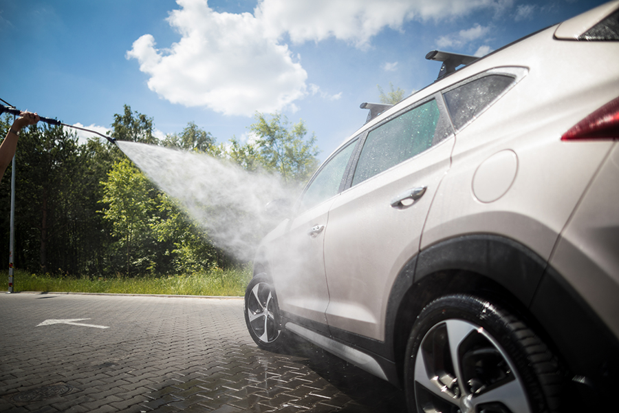 Manual car wash with pressurized water.